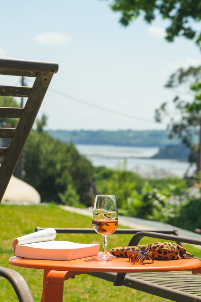 Un verre de rosé dans le jardin de l'Hôtel Les Agapanthes avec une jolie vue mer